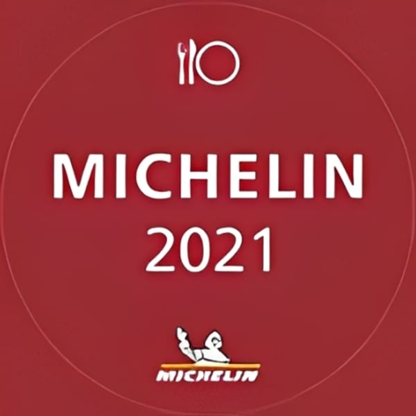 Red circular Michelin Guide 2021 award logo with a plate and cutlery icon.