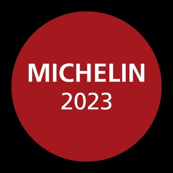 Red circular Michelin 2023 award logo on a black background.