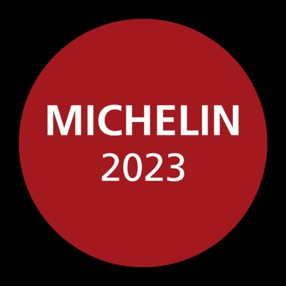 Red circular Michelin 2023 award logo on a black background.